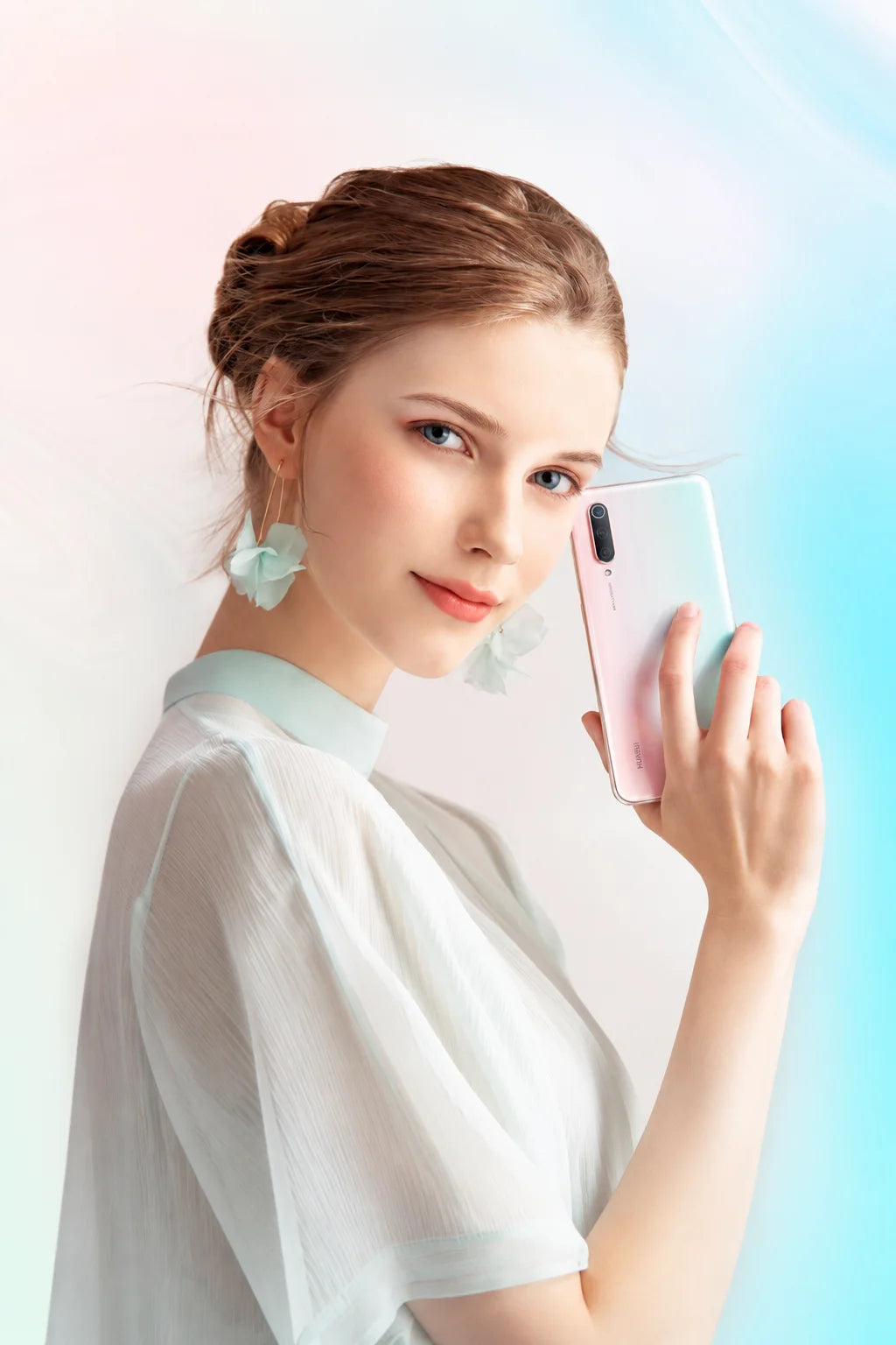 Young woman holding a Xiaomi smartphone with gradient finish in a premium studio portrait
